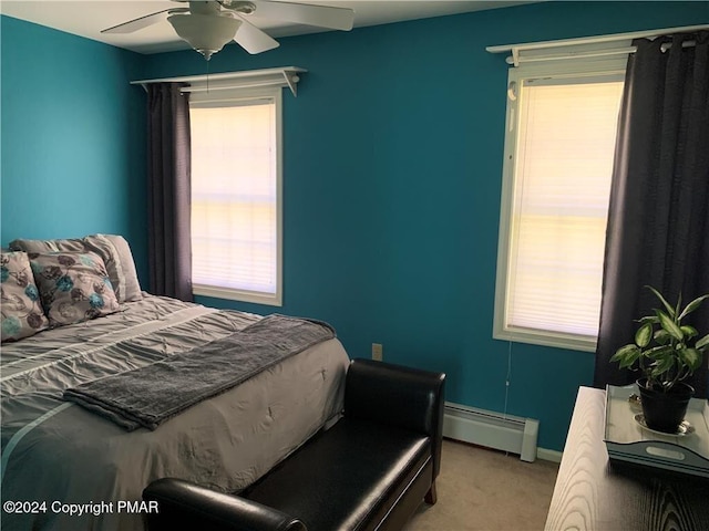 carpeted bedroom featuring baseboards, multiple windows, a baseboard heating unit, and a ceiling fan