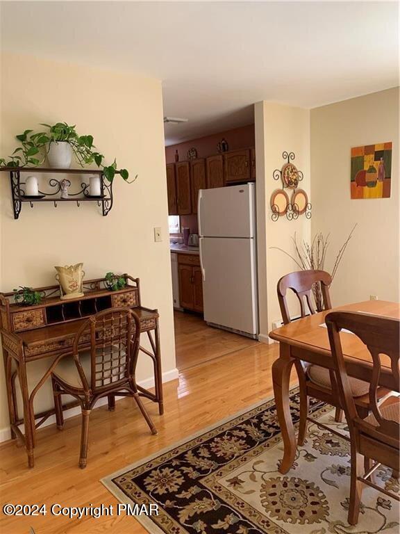 dining area with light wood-type flooring and baseboards