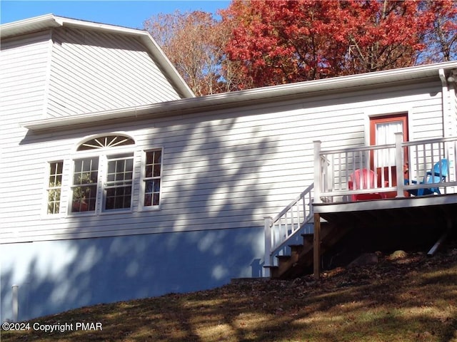 rear view of house featuring stairs and a wooden deck