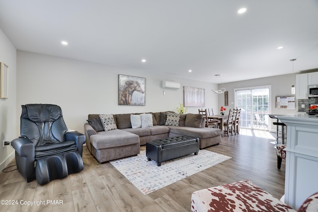 living room featuring recessed lighting, an AC wall unit, and light wood-style flooring