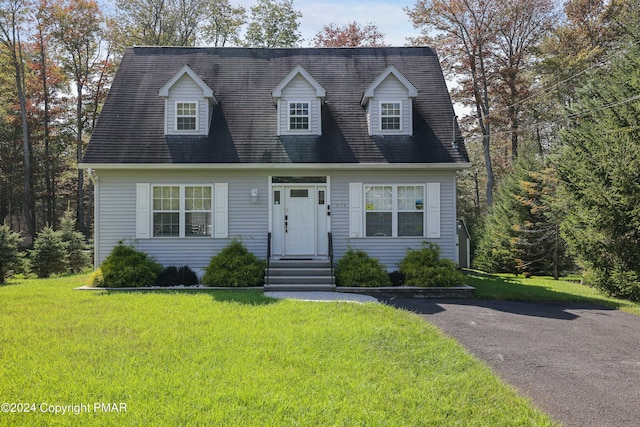 cape cod house featuring a front yard