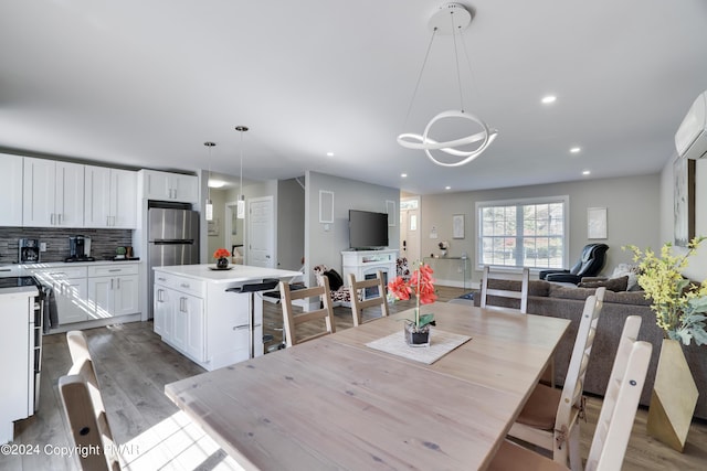 dining area with wood finished floors and recessed lighting