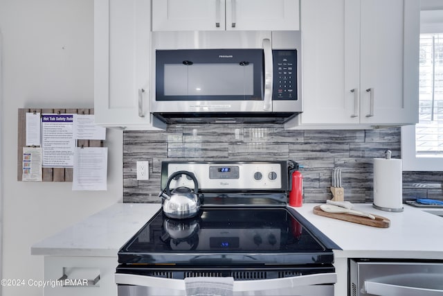 kitchen with white cabinetry, appliances with stainless steel finishes, backsplash, and a wealth of natural light