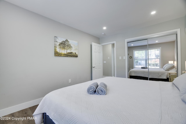 bedroom featuring a closet, baseboards, wood finished floors, and recessed lighting