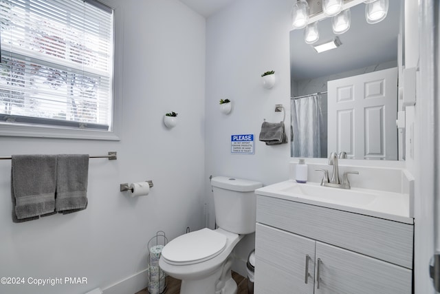 bathroom featuring a shower with curtain, vanity, and toilet