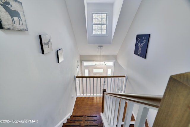 staircase featuring wood finished floors and baseboards