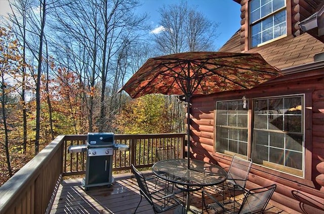 wooden terrace featuring outdoor dining area and grilling area