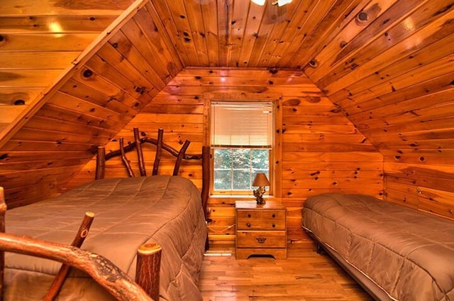 bedroom with vaulted ceiling, wood finished floors, wood ceiling, and wooden walls