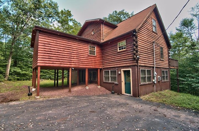 log home featuring log exterior and aphalt driveway