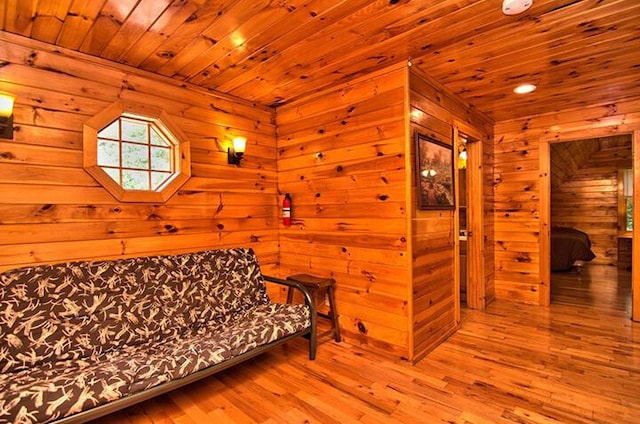 living area with wood walls, wood finished floors, and wood ceiling