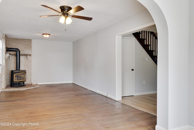 413 Old Rte 940, Pocono Pines, PA 18350 - unfurnished living room with a wood stove, light wood-style flooring, ceiling fan, stairway, and baseboards