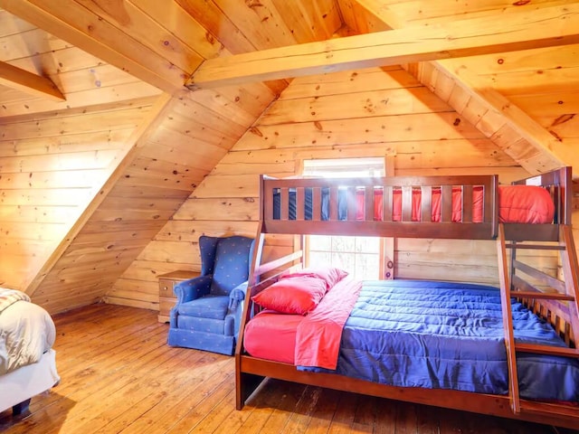 bedroom with vaulted ceiling with beams, hardwood / wood-style floors, and wooden walls