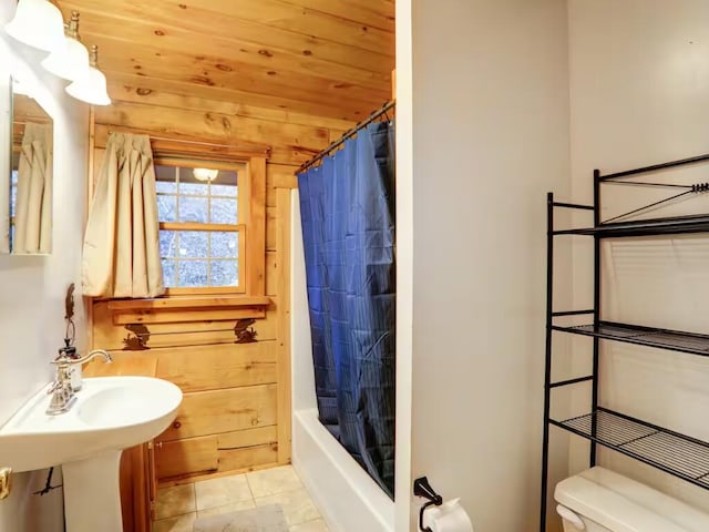 full bathroom featuring tile patterned flooring, wooden ceiling, shower / bathtub combination with curtain, and toilet