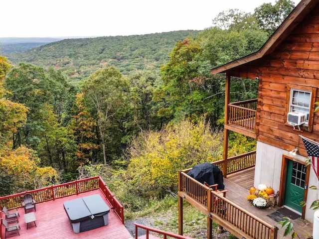 wooden terrace featuring a forest view and cooling unit