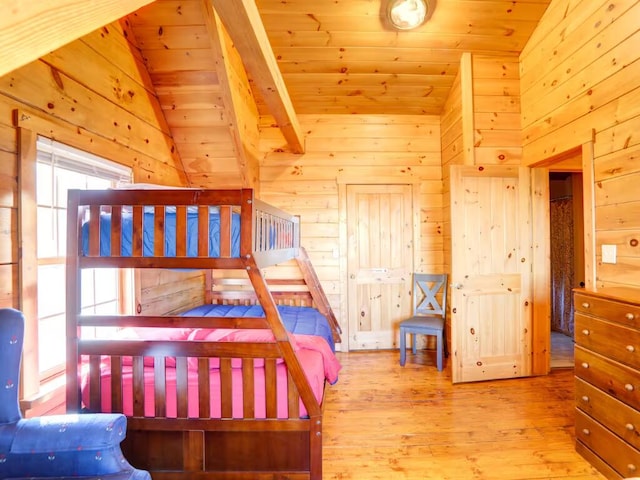 bedroom with lofted ceiling, wood ceiling, wood walls, and wood finished floors