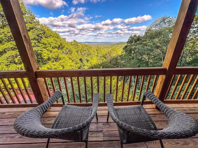 wooden terrace featuring a forest view