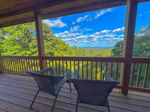 wooden deck with a wooded view