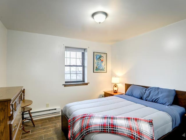 bedroom featuring a baseboard heating unit and wood finish floors