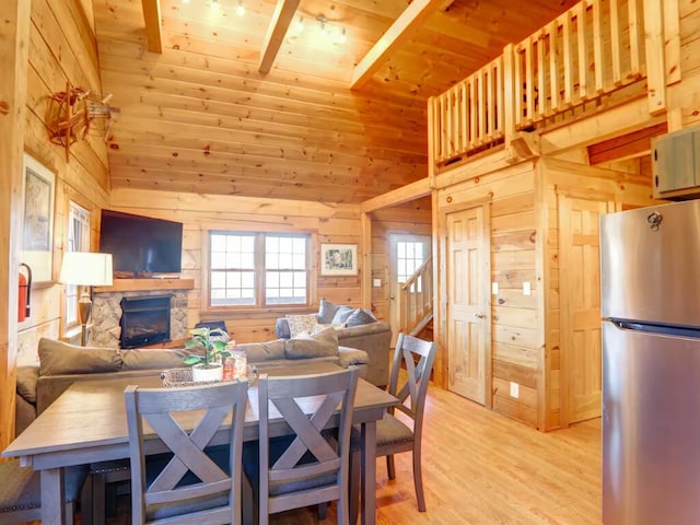 dining area with wood walls, light wood-type flooring, and wood ceiling