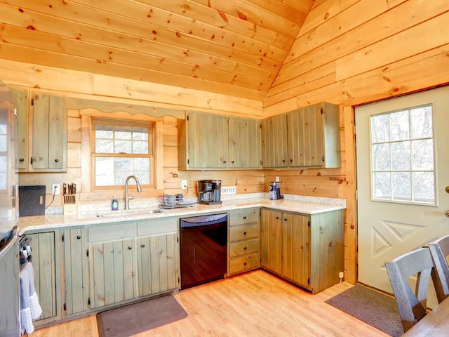 kitchen with light countertops, light wood-style floors, vaulted ceiling, a sink, and dishwasher