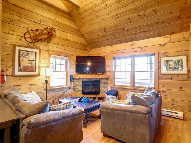 living area featuring a baseboard heating unit, a fireplace, wooden walls, and wood finished floors