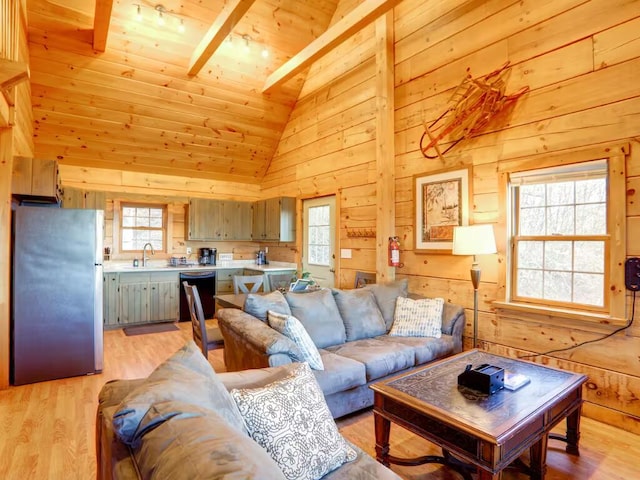 living area featuring light wood-style flooring, plenty of natural light, and wooden walls