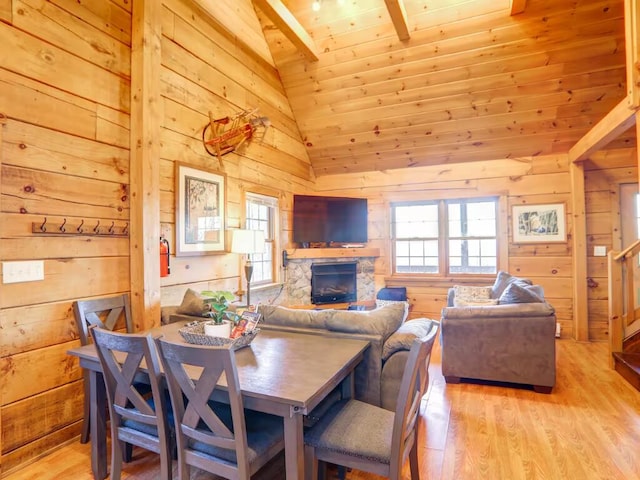 dining area featuring light wood-type flooring, wood walls, and plenty of natural light