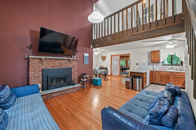 1117 Belaire Dr, East Stroudsburg, PA 18301 - living room featuring ceiling fan, light wood-style floors, a towering ceiling, and a fireplace