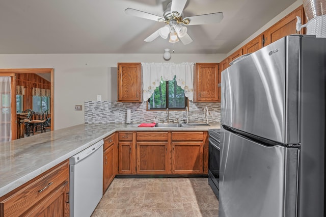 1117 Belaire Dr, East Stroudsburg, PA 18301 - kitchen featuring freestanding refrigerator, dishwasher, brown cabinetry, and light countertops