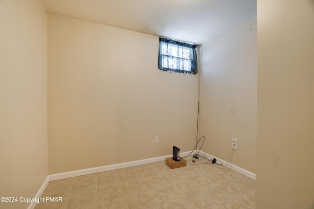 laundry room featuring light tile patterned floors and baseboards