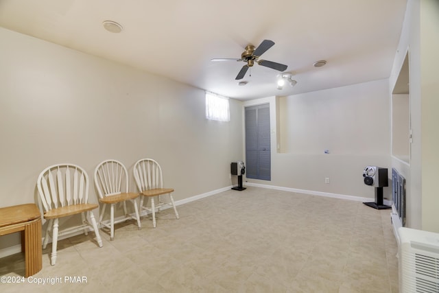 living area with ceiling fan and baseboards