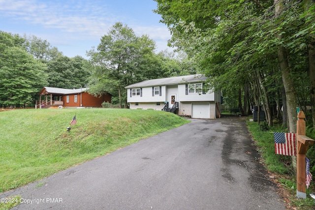 split foyer home with aphalt driveway, a front yard, and an attached garage