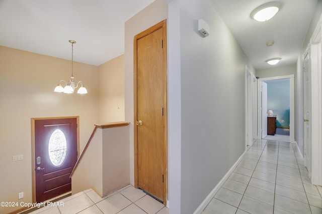 foyer entrance with an inviting chandelier, baseboards, and light tile patterned floors