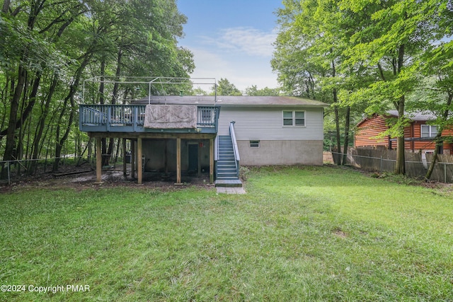 back of property featuring fence, stairway, a lawn, and a wooden deck