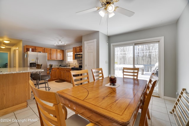 dining room with a ceiling fan, light tile patterned flooring, and baseboards