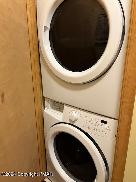 laundry room with stacked washer / dryer