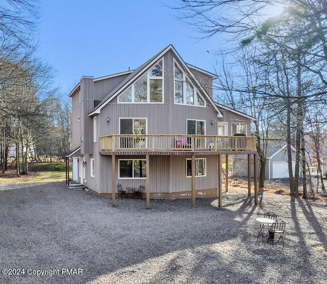 back of property featuring an outbuilding and a wooden deck