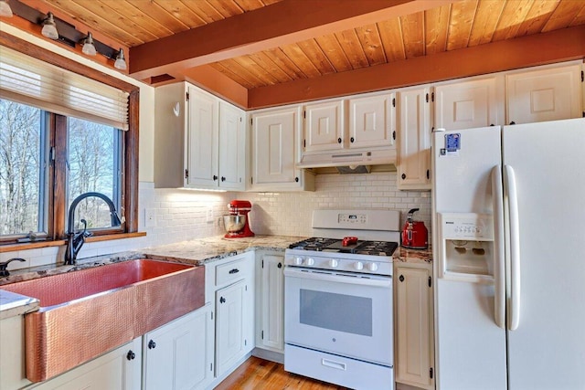 kitchen featuring under cabinet range hood, a sink, tasteful backsplash, and white appliances