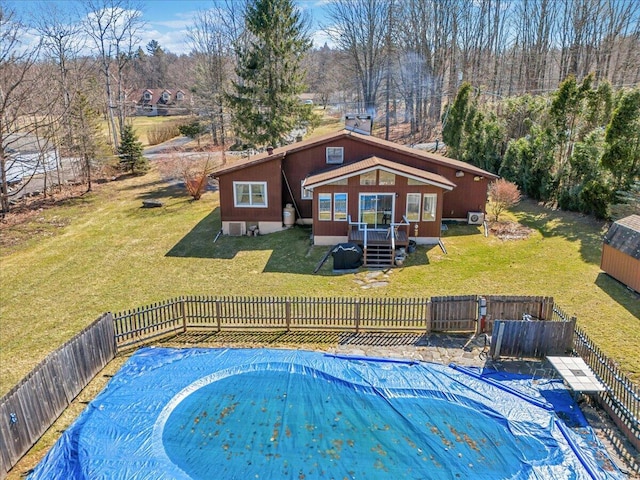 view of swimming pool with a lawn, a wooden deck, and fence