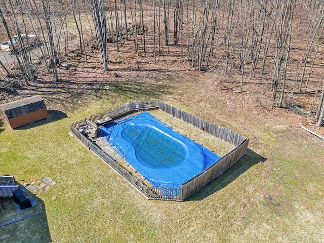 view of pool featuring a lawn, an outbuilding, and fence
