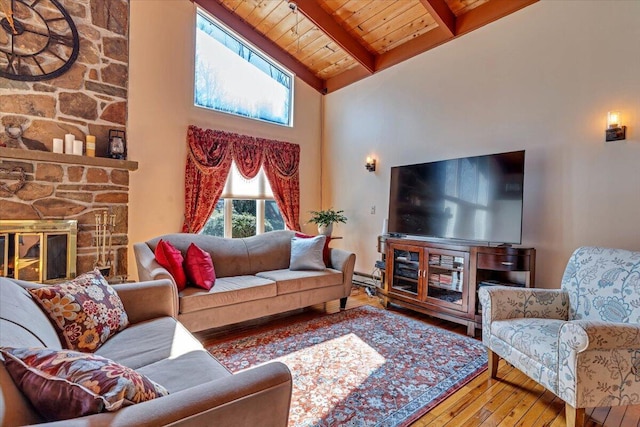 living area with high vaulted ceiling, wooden ceiling, a fireplace, beamed ceiling, and hardwood / wood-style floors