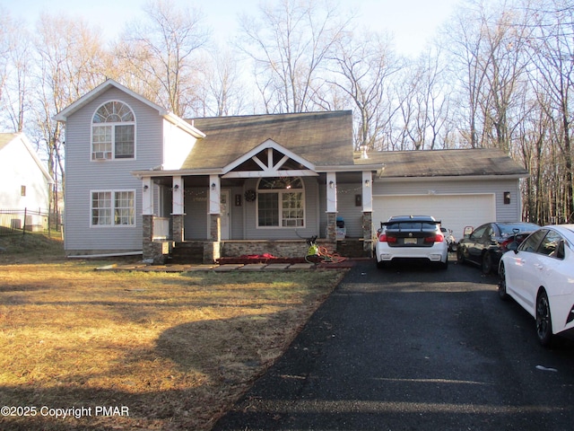 view of front facade with a garage, stone siding, aphalt driveway, covered porch, and a front lawn