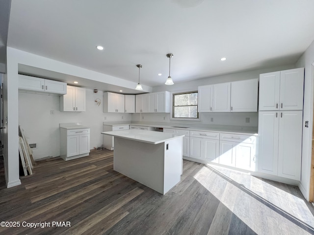 kitchen with dark wood finished floors, a kitchen island, white cabinetry, pendant lighting, and recessed lighting