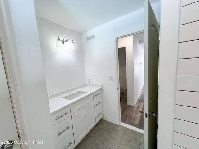 bathroom featuring visible vents, vanity, baseboards, and tile patterned floors