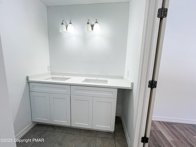 bathroom with double vanity and baseboards