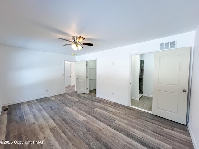 unfurnished bedroom with baseboards, visible vents, and wood finished floors