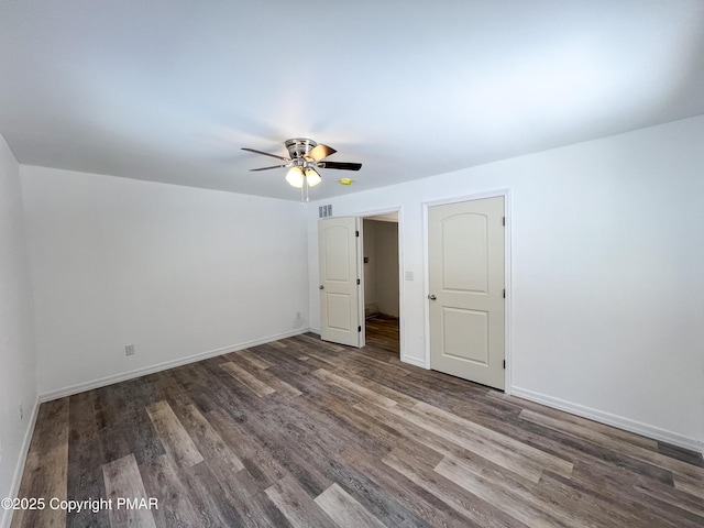 unfurnished bedroom with a ceiling fan, visible vents, baseboards, and wood finished floors