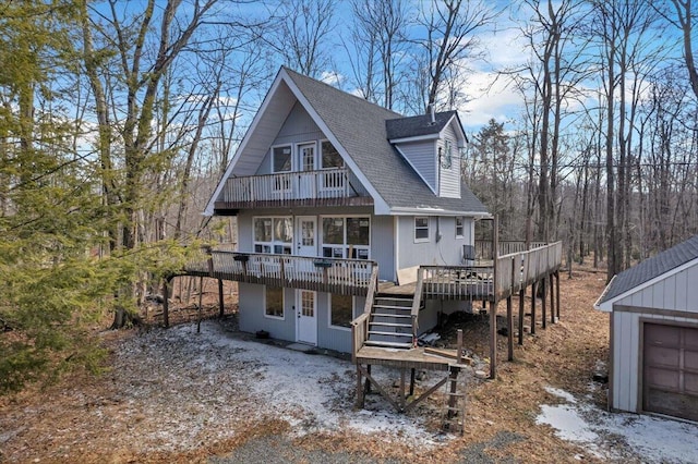 view of front of home featuring stairway, a deck, and a shingled roof