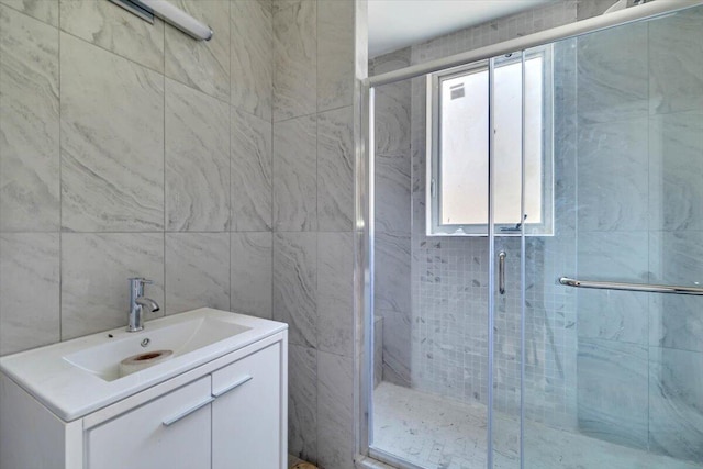 full bathroom with vanity, tile walls, and a stall shower