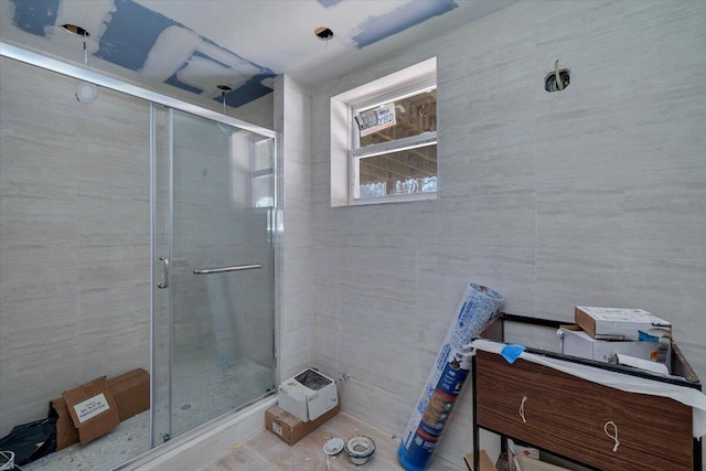 bathroom with tile walls and a stall shower